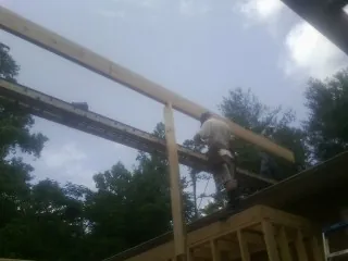 Carpenter setting a ridge beam over a new addition frame — Ice Dam Removal by Roofing Brothers in Manteca