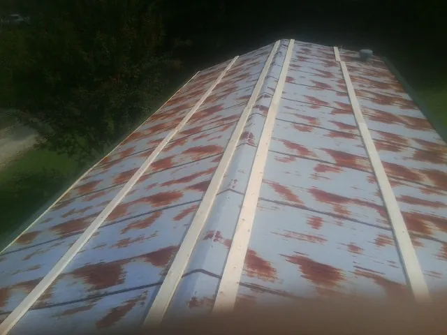 Rusted metal roof panels with new wood purlins before replacement — Storm Damage Roof Repair in Manteca by Roofing Brothers