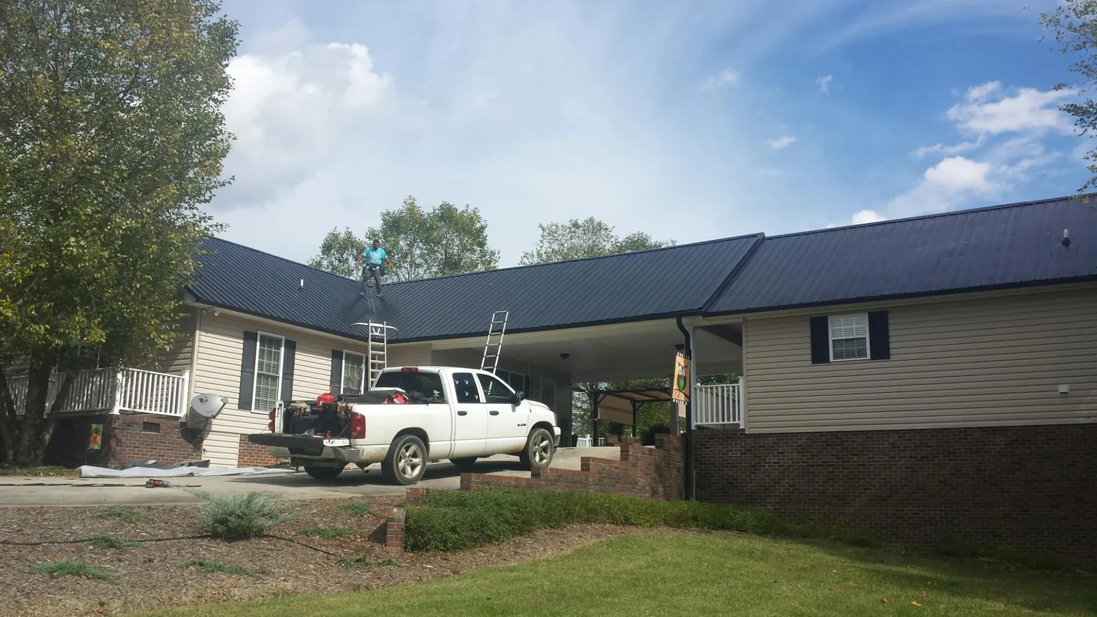 Black metal roof over a home and attached breezeway with ladders set in Manteca