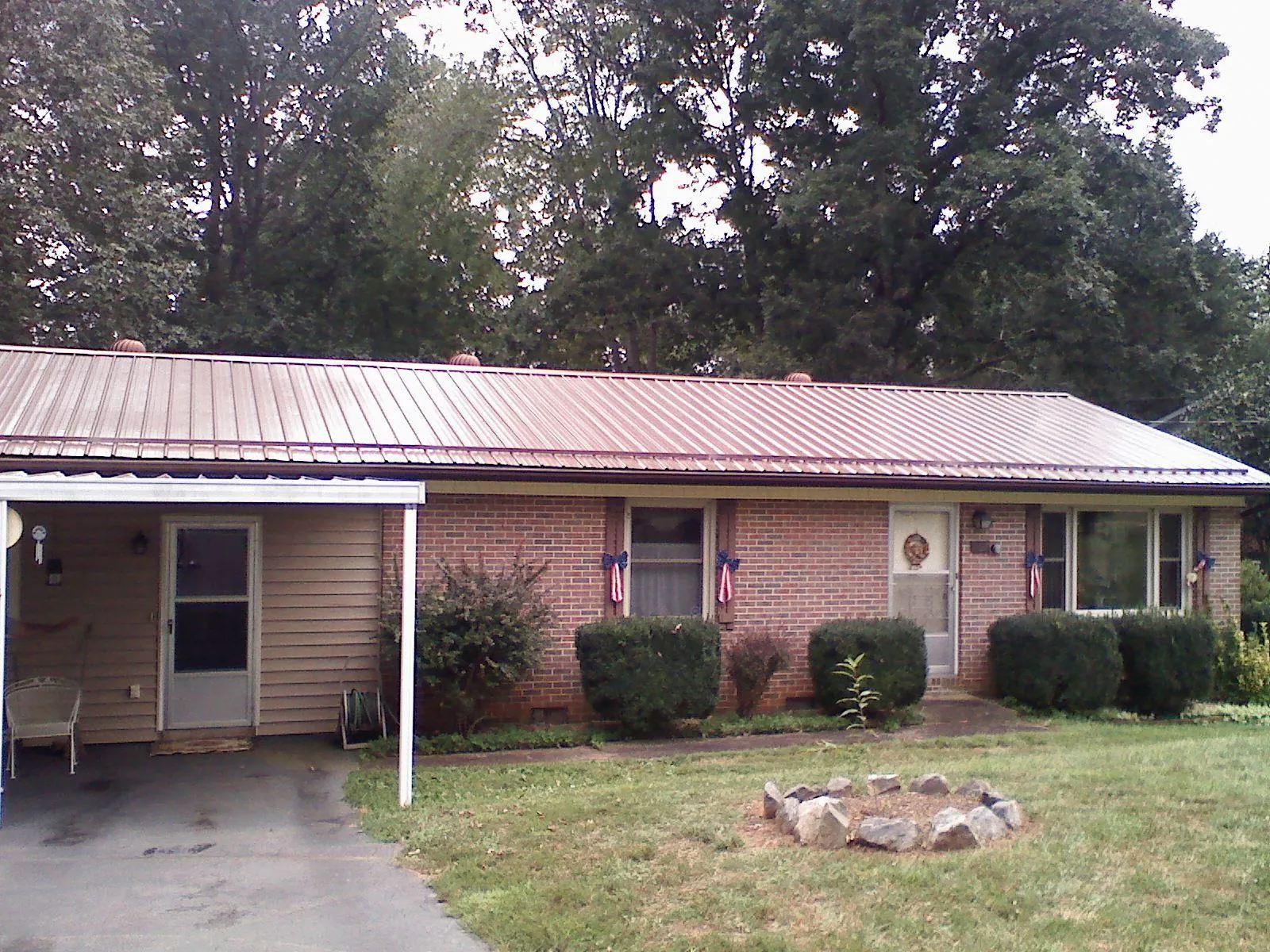 Bronze metal roof and carport on a brick ranch home — Roof Repair work by our crew in Manteca